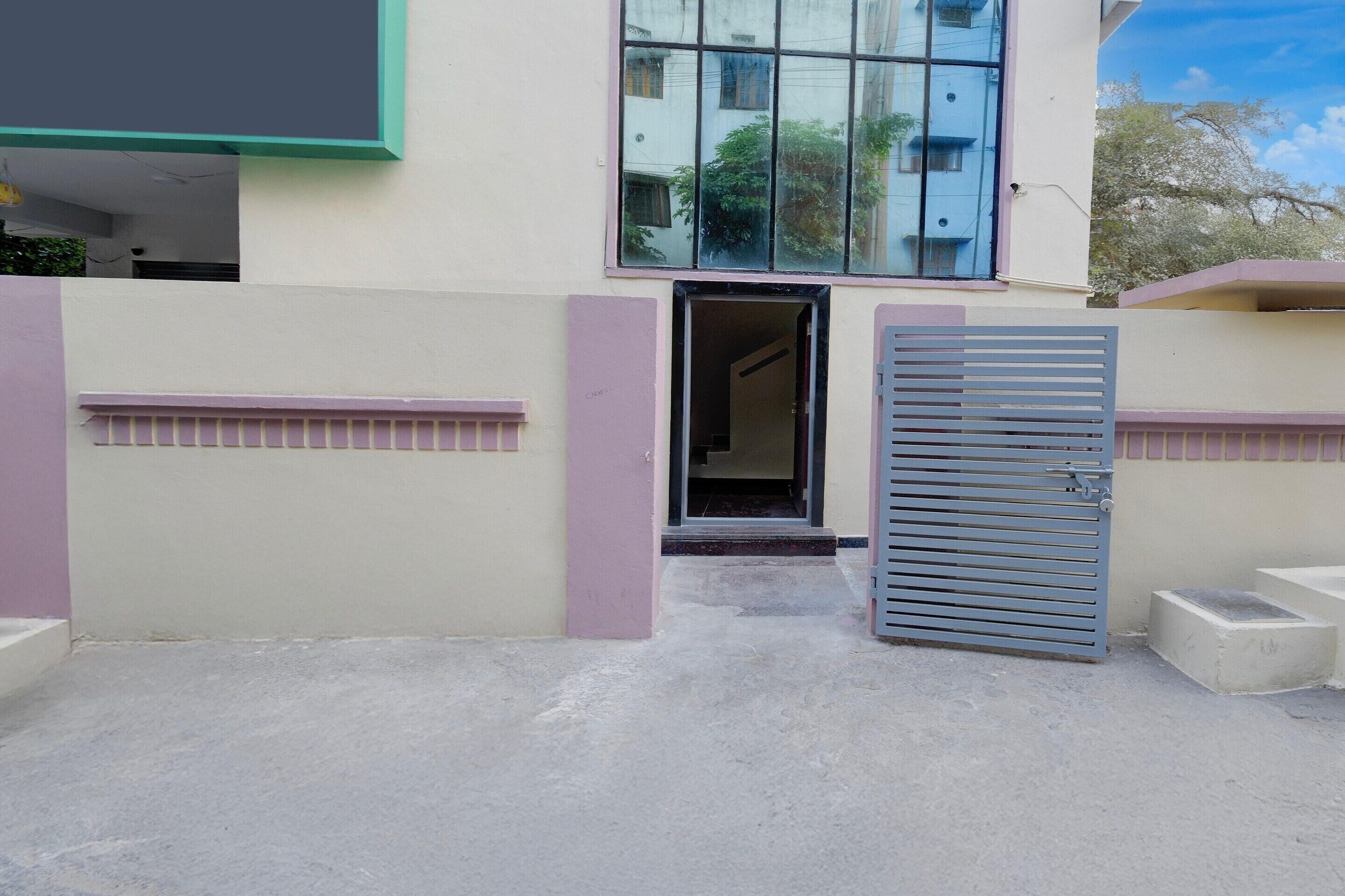 A gated entrance to a building with a visible door and steps leading to a covered area.