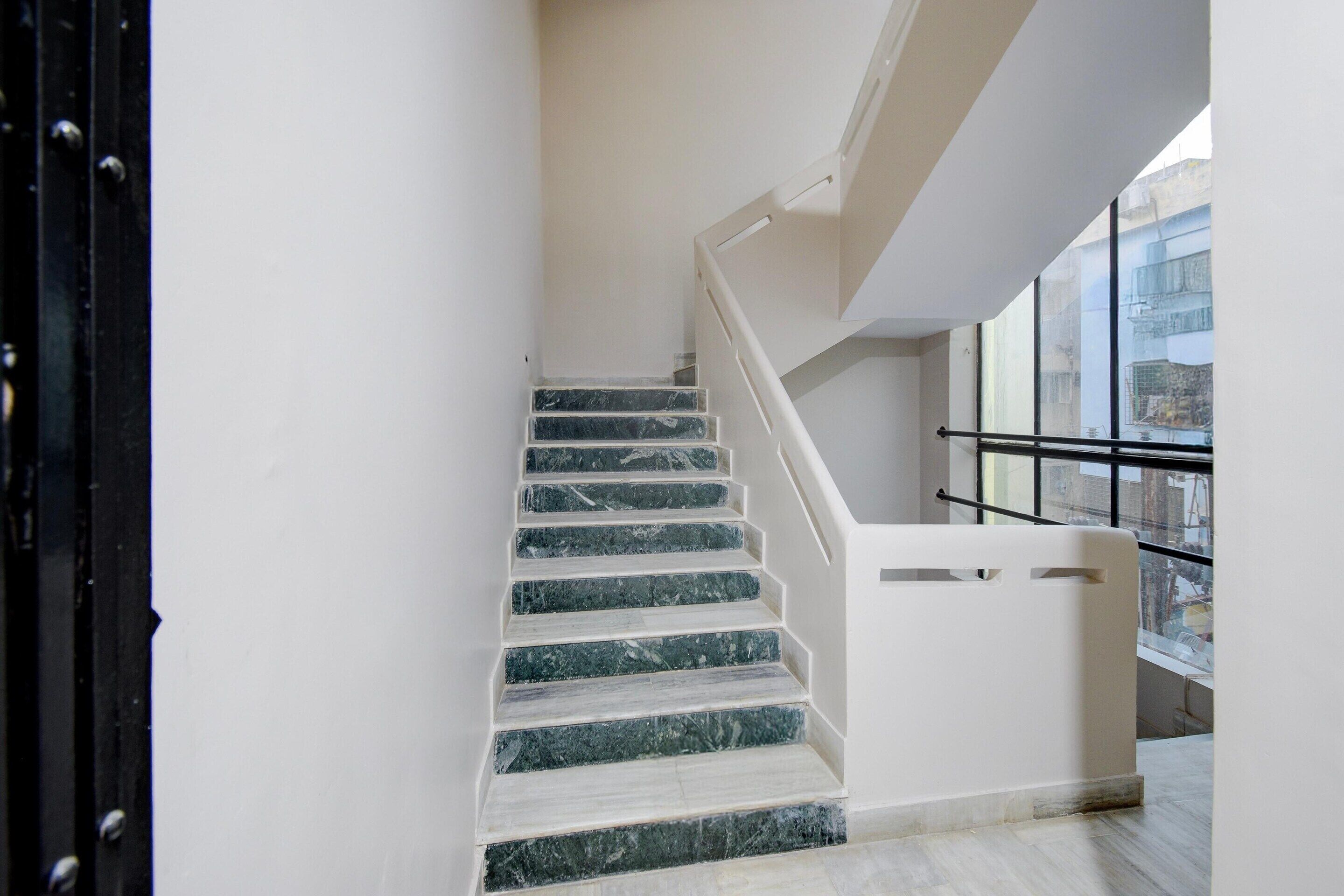 A staircase with marble steps and a handrail, leading to an upper floor.