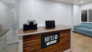 A hotel reception desk with a sign indicating it is serviced by OYO. - Deluxe Room Adithya Stay (Hyderabad)