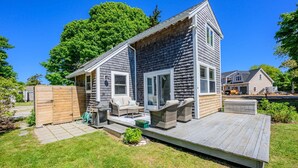 Een huis met twee verdiepingen, een terras, een binnenplaats en een omheinde tuin.