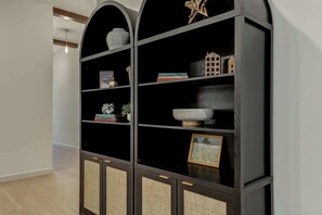 Un estante negro con objetos decorativos y un cuadro enmarcado.
