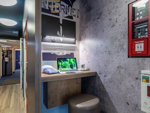 A desk with a laptop, a coffee cup, and a bulletin board in a modern office setting. - Ibis Budget Bremen City Sud (Bremen)