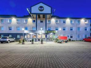 Een bed and breakfast hotel met een modern design, een verharde oprit en een parkeerplaats.