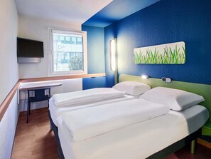 A hotel room with a bed, a desk, a chair, a TV, and a window. - B B Hotel Bremen Sud (Bremen)