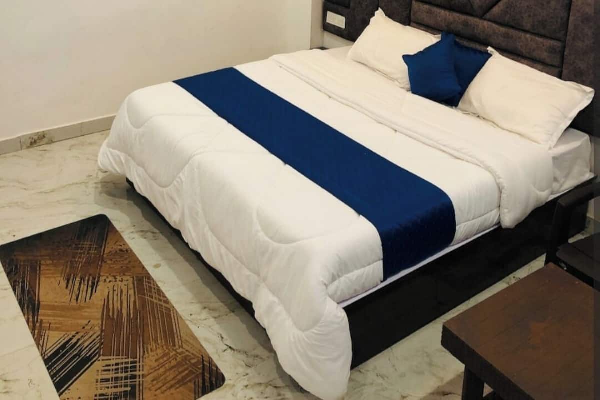 A bedroom with a bed, a ceiling fan, and a small table.