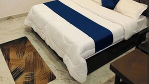 Un dormitorio con una cama, un ventilador de techo y una mesita.