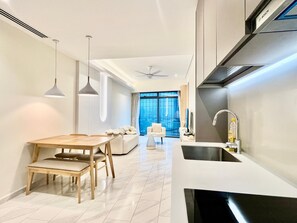 Een moderne keuken met een inbouwoven, een spoelbak en een eethoek met een houten tafel en stoelen.