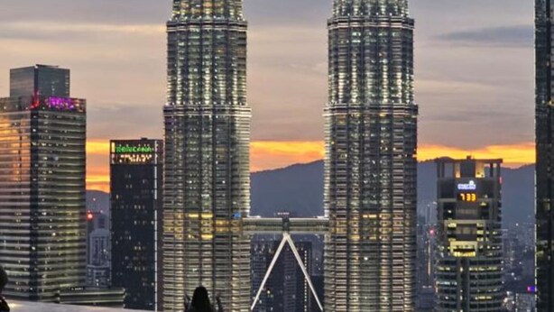 A view of the Petronas Twin Towers from an indoor pool area with a cityscape in the background. - Eaton Residences by ubook (Kuala Lumpur)