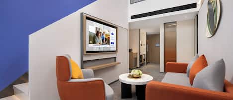 Suite Estudio Business, vistas a la montaña | Zona de estar | Televisión LCD de 50 pulgadas con canales por cable, películas de pago