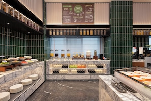 A buffet area with various food options, a coffee station, and a menu board. - Hampton by Hilton Zhangjiajie (Zhangjiajie)