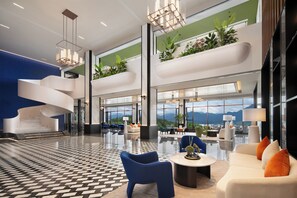 A modern hotel lobby with a spiral staircase, seating areas, and large windows offering mountain views. - Hampton by Hilton Zhangjiajie (Zhangjiajie)