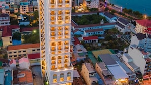 A high-rise hotel with multiple floors, balconies, and a view of the sea. - Aston Nha Trang City Hotel (Nha Trang)