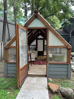 Une petite construction en bois, dotée d’un toit incliné et d’une porte donnant sur l’intérieur.