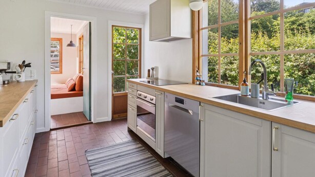 Una cocina moderna con un ventanal grande, electrodomésticos de acero inoxidable y una encimera de madera.