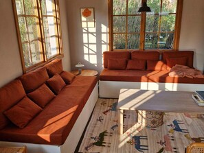 Ein gemütliches Wohnzimmer mit einer Couch, einem Couchtisch und einem Teppich mit Tiermotiven.