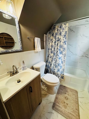 A bathroom with a sink, toilet, and bathtub. - The Wildflower Hideout (Cheyenne)