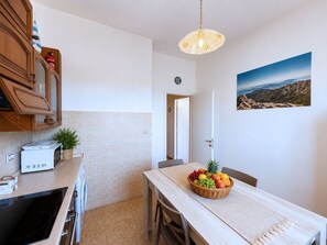 A compact kitchen with a microwave, toaster, and a fruit basket on the table. - Le Finestre sul Porto (Portoferraio)