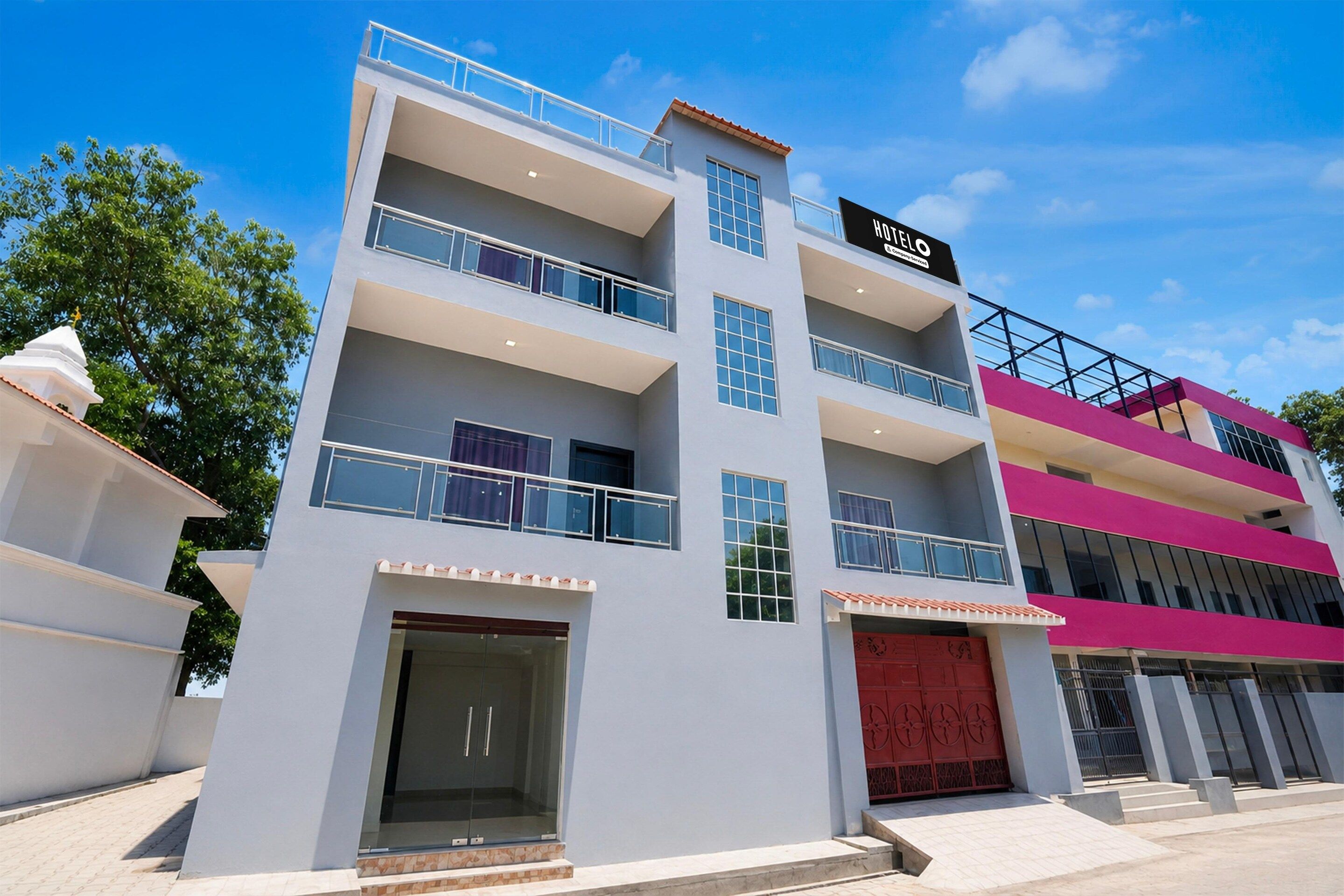 A multi-story hotel with a modern facade, balconies, and a prominent entrance.
