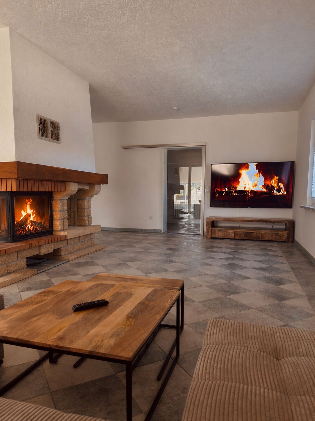 Ein Wohnzimmer mit Kamin, Fernseher und einer Couch.
