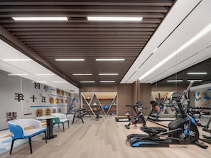 A modern gym with exercise equipment, a seating area, and a wall with motivational text. - Holiday Inn Express Hai'an Railway Station (Nantong)