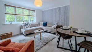 Ein modernes Wohnzimmer mit einer Couch, einem Esstisch und einer Wand mit Muster.