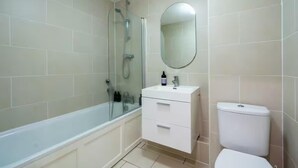 Ein Badezimmer mit Badewanne, Waschbecken mit Spiegel und Toilette.