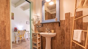 A bathroom with a pedestal sink, wooden wall paneling, a towel rack, and a mirror above the sink. - Tra Cielo e Mare - Rooms Rio Marina - Tra Cielo e Mare - Curcuma (Rio Marina)