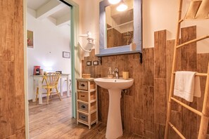 Ein Badezimmer mit einem Standwaschbecken, Holzvertäfelung, einem Handtuchhalter und einem Spiegel über dem Waschbecken.