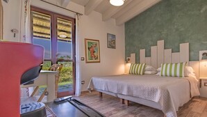 Ein Schlafzimmer mit einem Bett, einem Schreibtisch, einem Stuhl und einem Fenster mit Vorhängen.