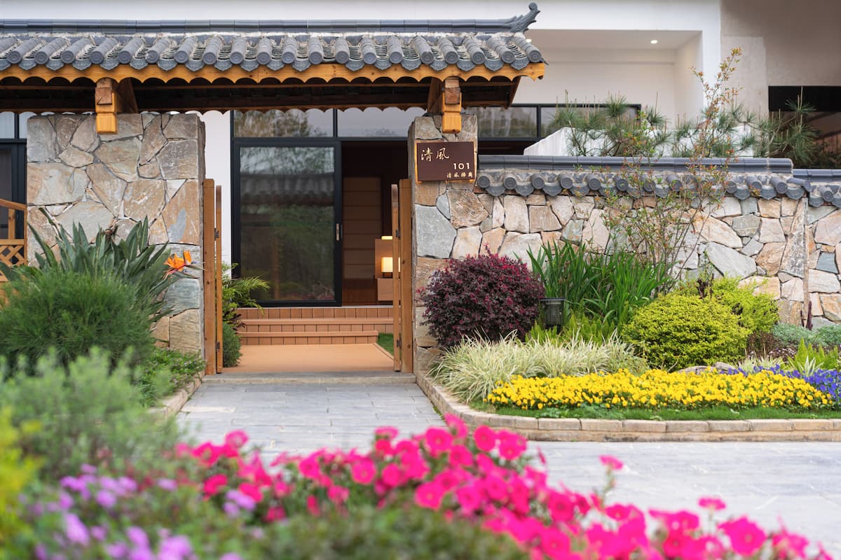 Un edificio de estilo coreano tradicional con fachada de piedra, entrada de madera y un letrero que indica la dirección.