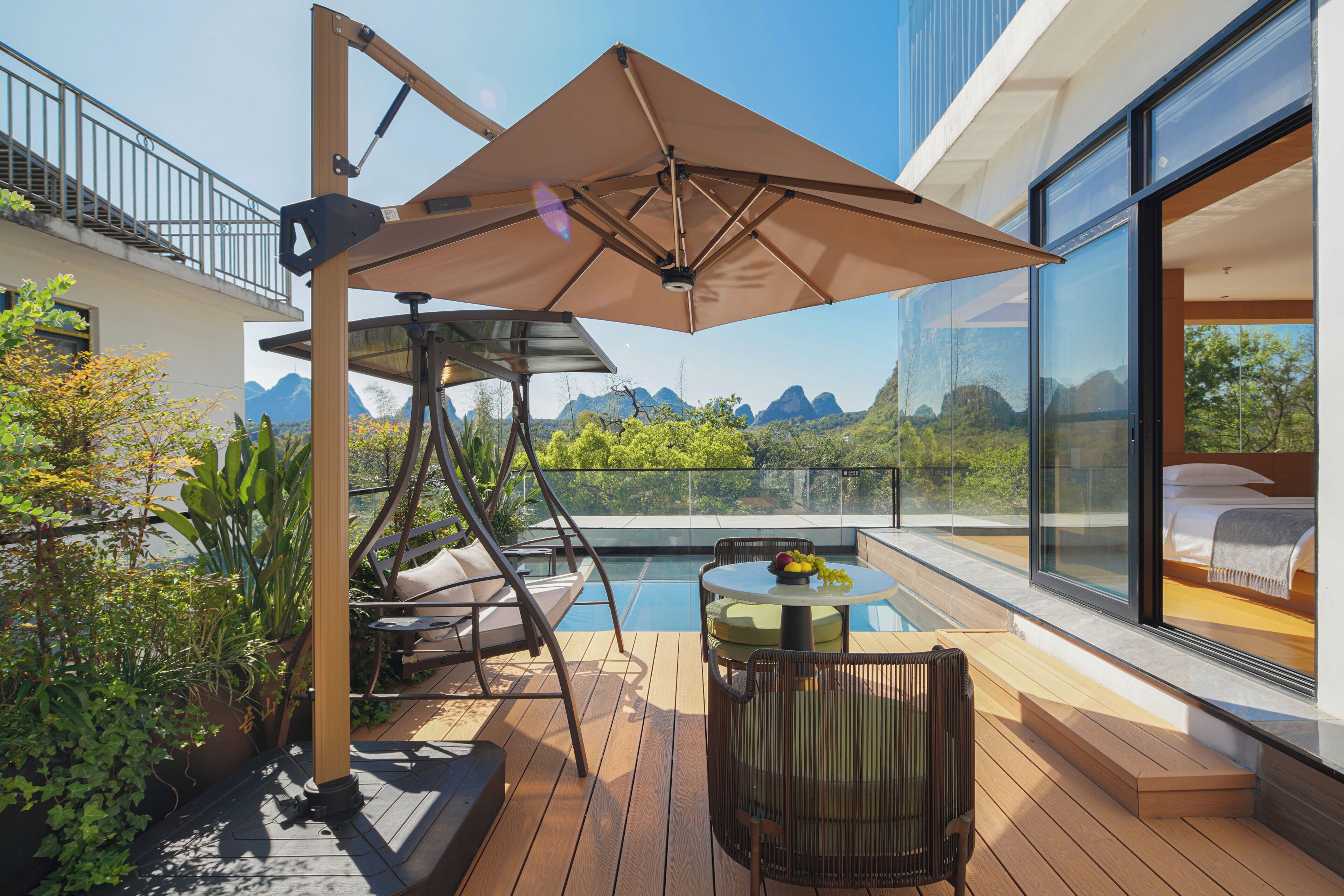 Una terraza moderna al aire libre con piscina, zona de comedor y dormitorio con vistas.