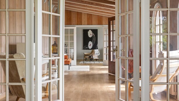 An open interior space with wooden paneling, a central seating area with chairs, and a large abstract painting on the wall. - 3 bedroom stunning home in Varberg (Varberg)