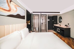A modern hotel room with a large bed, a bathroom with a shower, a vanity with a mirror, and a painting on the wall. - Verse Manor Hotel Shanghai (Shanghai)