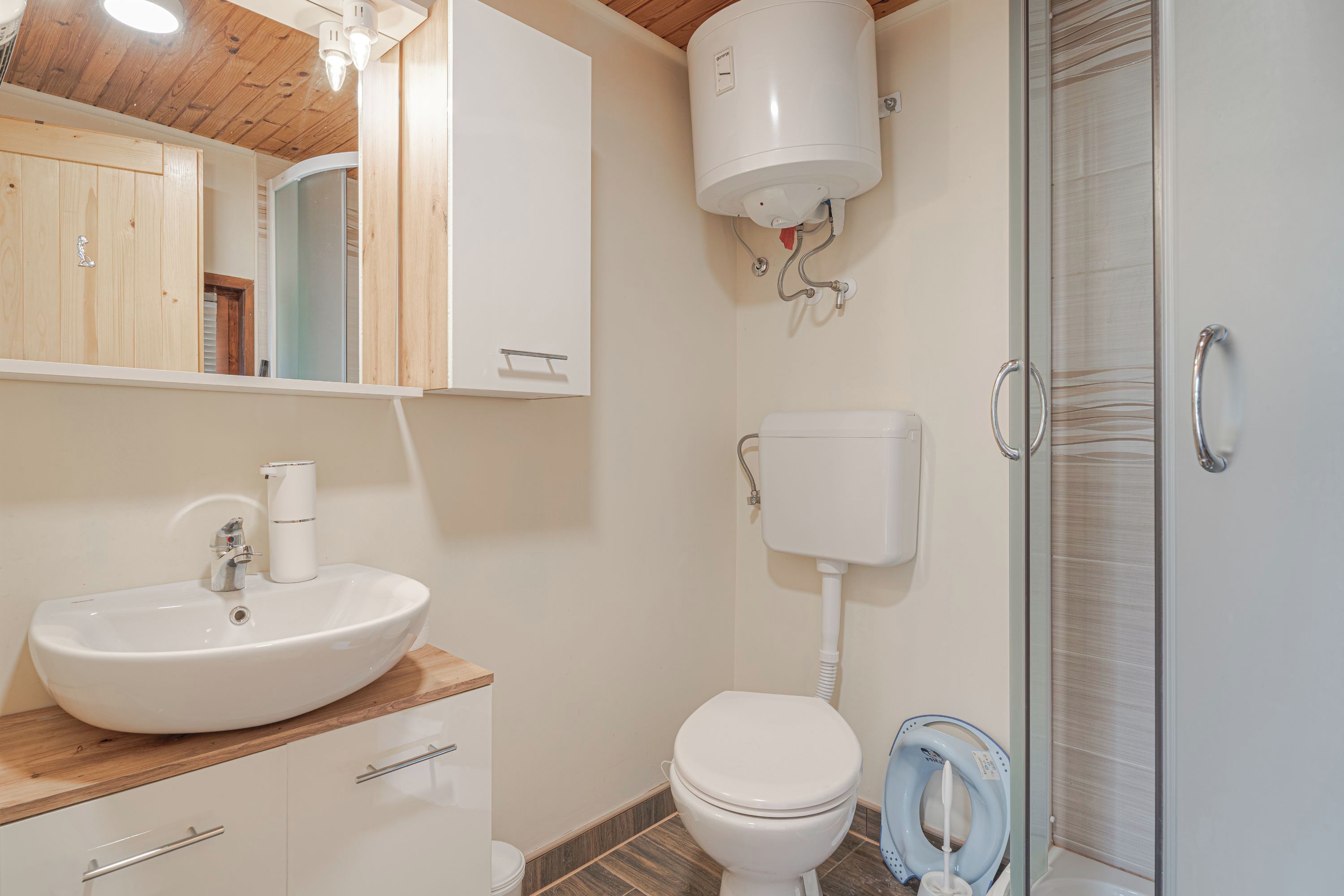 A bathroom with a sink, toilet, and shower.