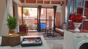 A laundry area with a washing machine, a table with a magazine, and a bench. - DhruvDhanush(2-bedroom with AC/2 attached bathroom in lovely Ullal/deralakatte (Ullal)