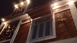 A two-story building with a balcony, a window, and a recessed ceiling with circular cutouts. - DhruvDhanush(2-bedroom with AC/2 attached bathroom in lovely Ullal/deralakatte (Ullal)