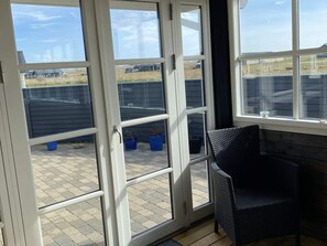A room with a large sliding glass door leading to an outdoor patio area. - 4 Star Holiday Home in Harboore (Harboore)
