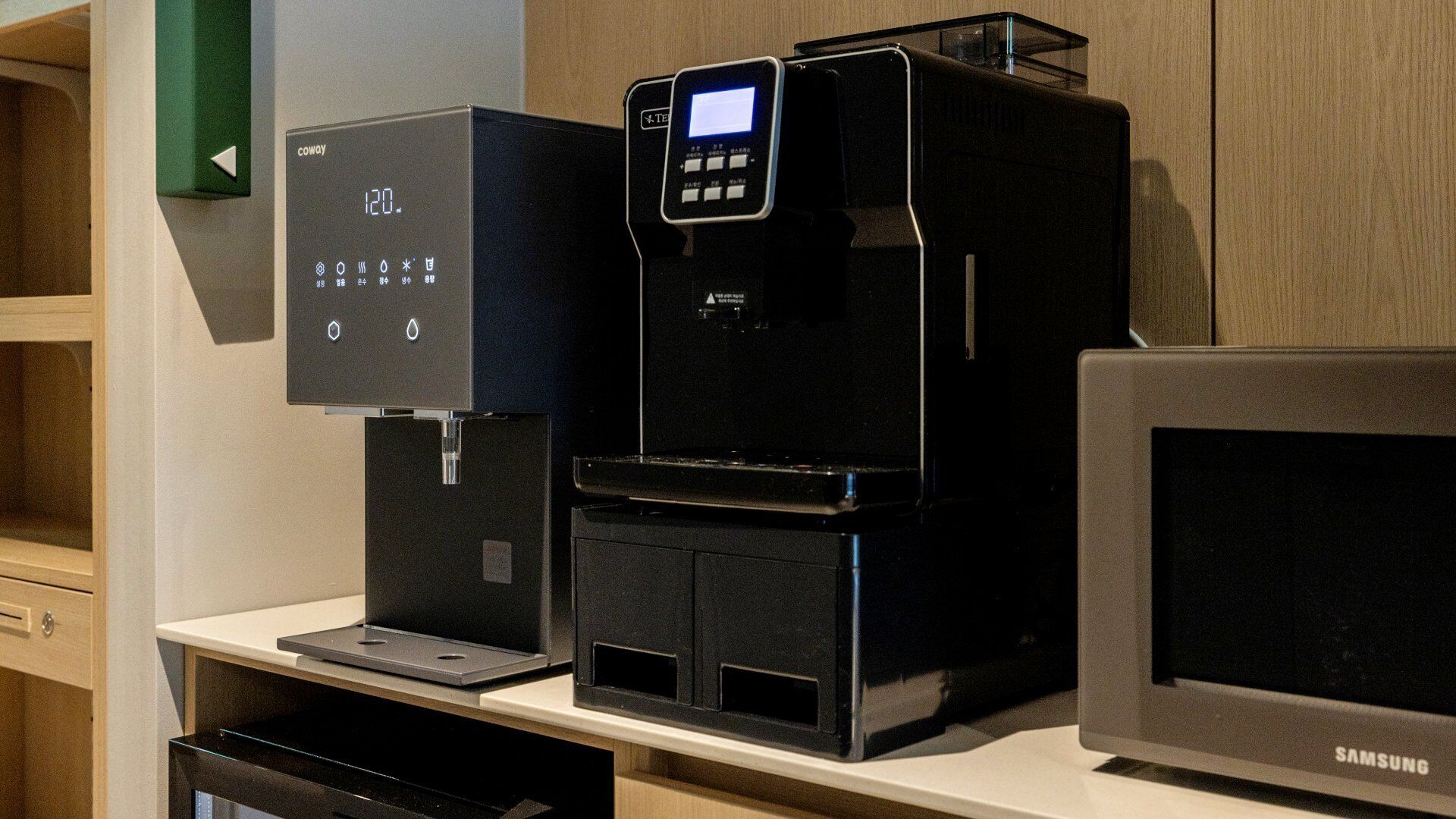 A kitchen area with a coffee machine, a microwave, and a Samsung refrigerator.