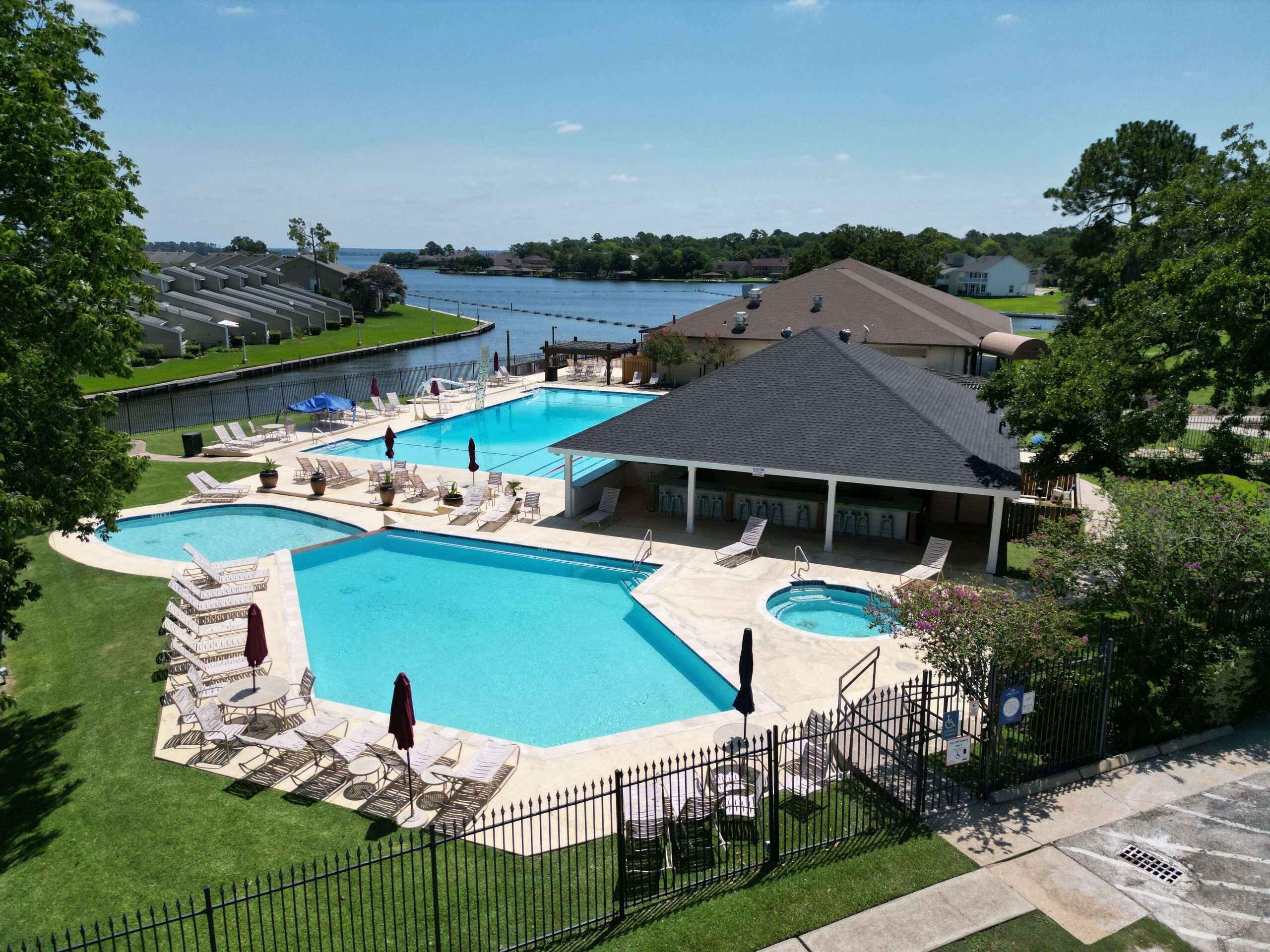 A swimming pool area with multiple pools, lounge chairs, and a covered seating area.