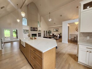 A spacious kitchen with a large island, wooden cabinets, and pendant lighting. - Terra Luxe @ Lake Conroe; Luxury Golf and Lake Retreat at April Sound (Conroe)