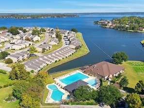A residential area with a large swimming pool, houses, and a body of water. - Terra Luxe @ Lake Conroe; Luxury Golf and Lake Retreat at April Sound (Conroe)