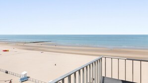 A beach view from a balcony with a railing, a lifeguard tower, and a clear sky. - Sea view and comfort in Middelkerke (Middelkerke)