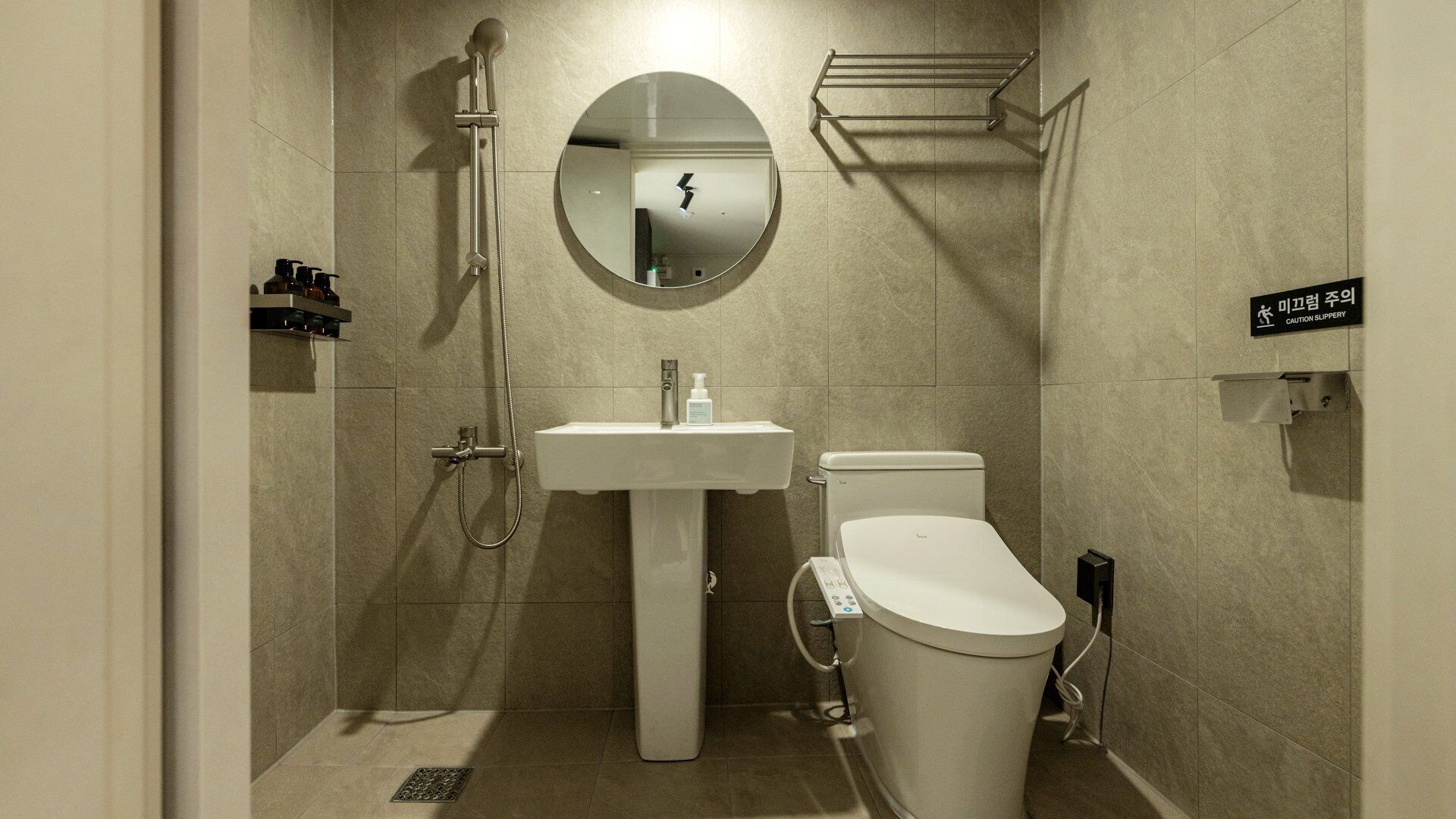 A modern bathroom with a toilet, sink, and shower.