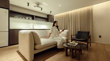 Una sala de estar moderna con un sofá, una mesa de centro y un sillón.