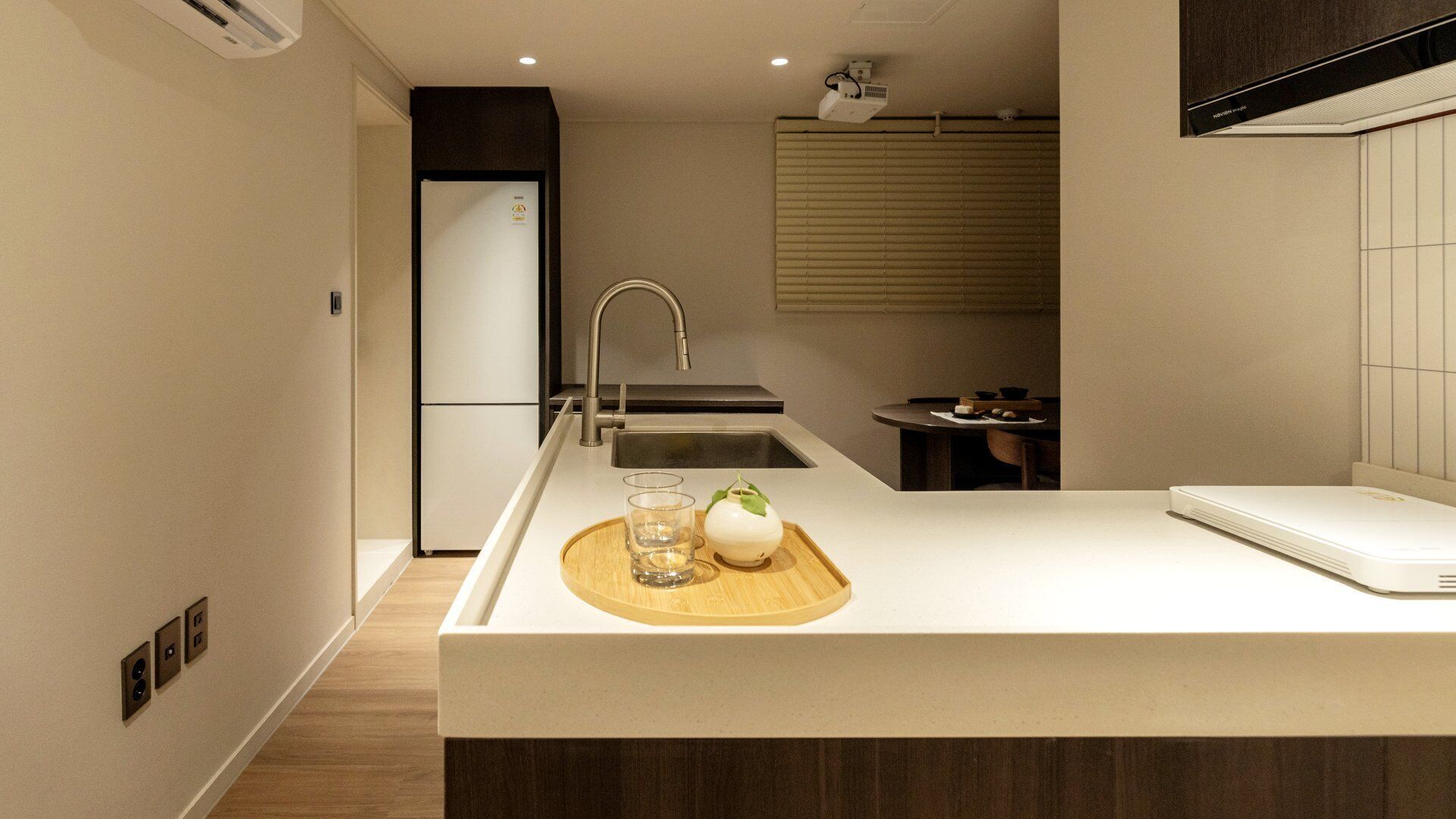 A modern kitchen with a central island, a built-in sink, and a compact dining area.