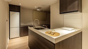 Una cocina moderna con una isla central, un lavamanos integrado y una ventana con persianas.