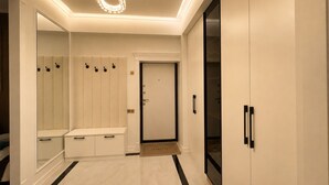 A modern hallway with a bench, a door, and a wardrobe.
