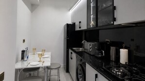 A modern kitchen with a dining area, featuring a sink, stove, and cabinets.