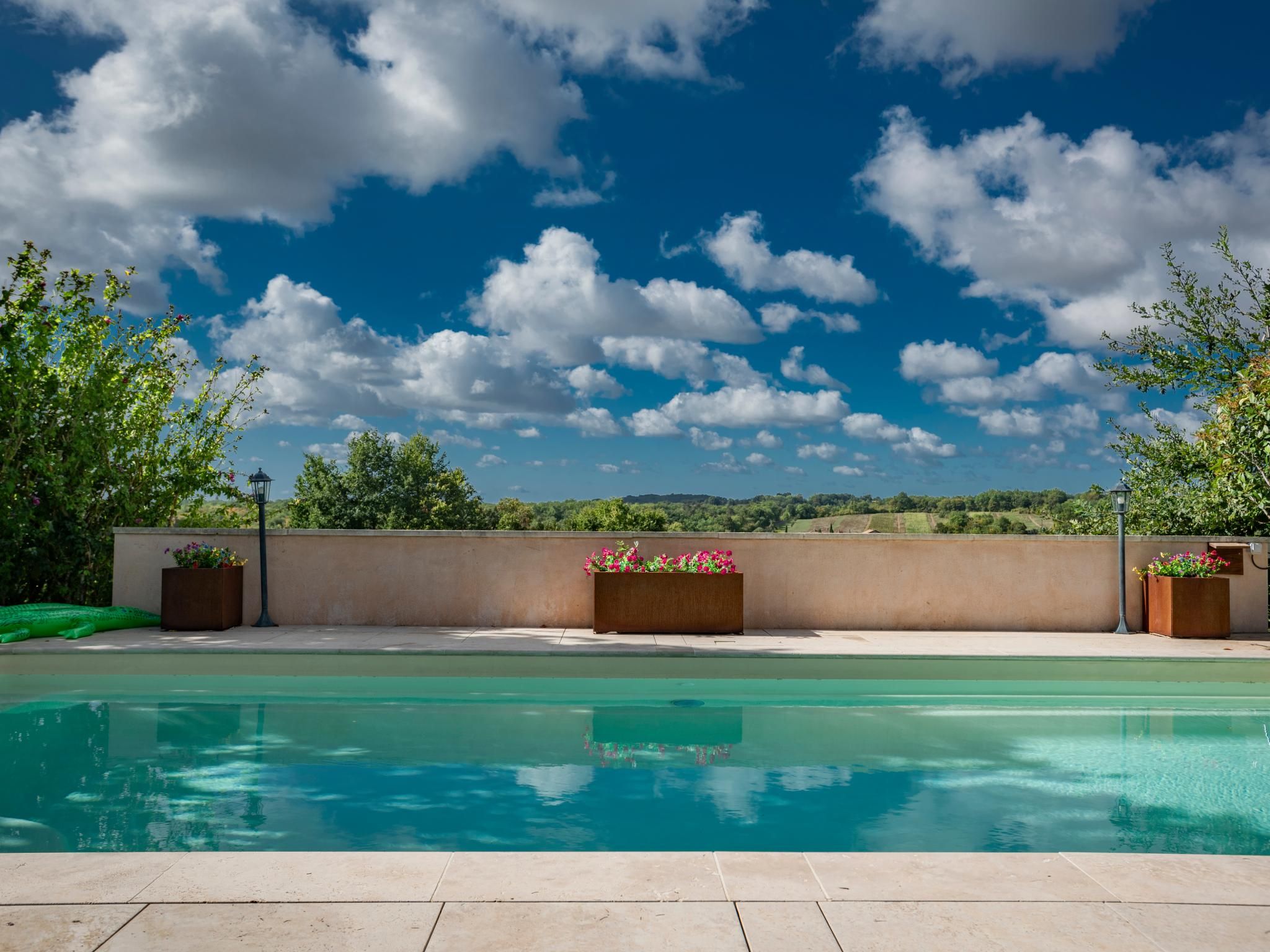 Piscina com vista para o céu e colinas ao longe.