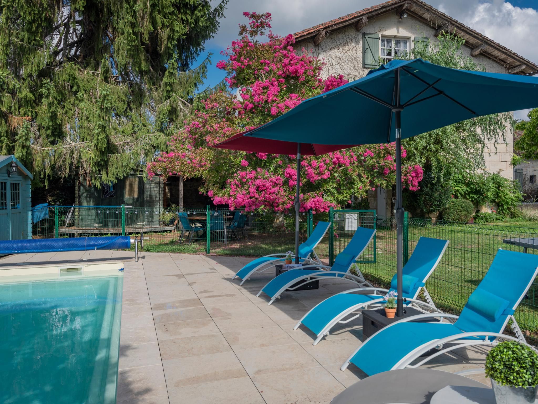 Un espace aménagé au bord de la piscine, avec des chaises longues et une piscine.